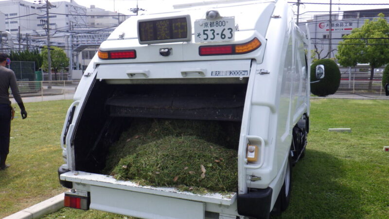 京都南部(久御山町・八幡市)の法人除草で活躍する大型パッカー車への草積み込み風景